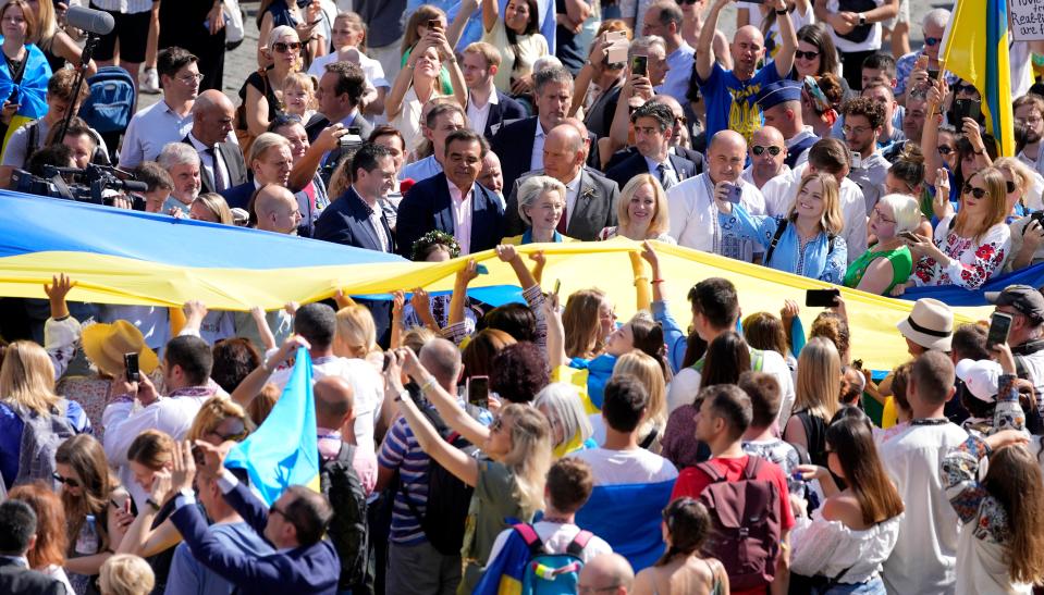 European Commission president Ursula von der Leyen marches beside a Ukrainian flag in Brussels. (AP)