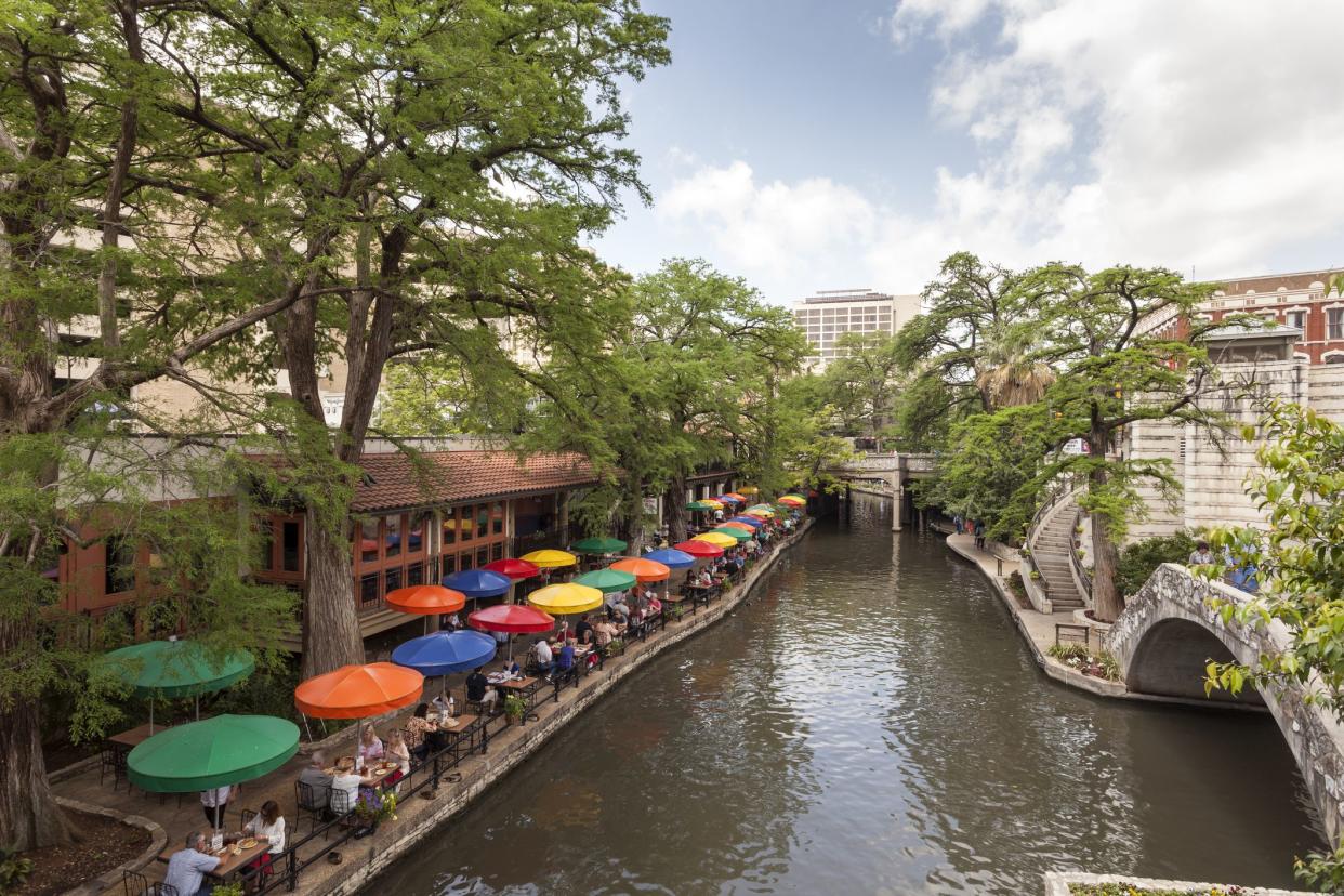 San Antonio, Tx, USA - April 11, 2016: The famous San Antonio River Walk and a cafe with colorful umbrellas.