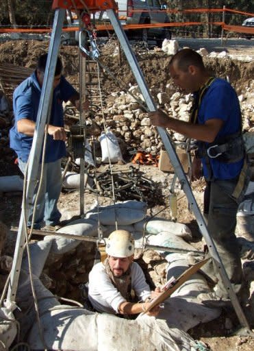 A handout picture released by Israel's Antiquities Authority shows Israeli archaeologists working at the site of a well that was discovered in the Jezreel Valley in the northern Galilee region. The well dates back to the Neolithic period some 8,500 years ago