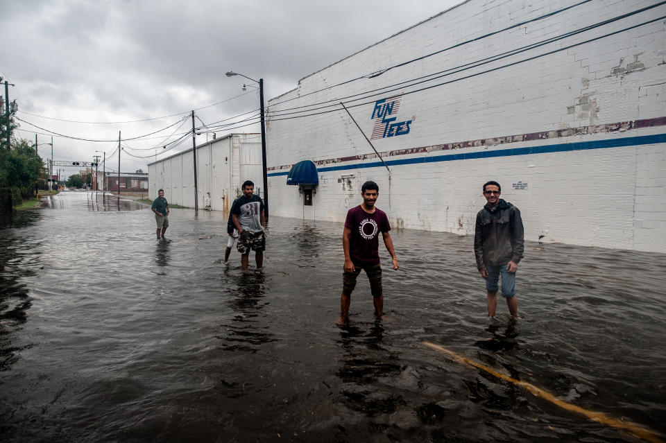 Residents of Lumberton walk through floodwaters near downtown as the Lumber River rises on Sunday.