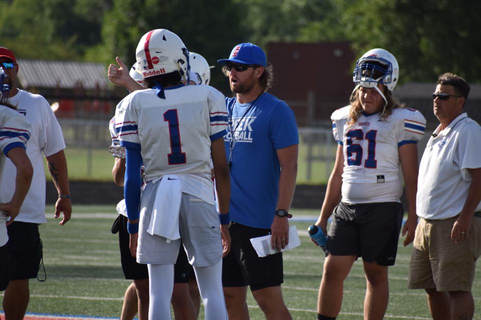 Indian Creek head coach Casey Gillin instructs first-year quarterback Arjun Lothe during the Braves' scrimmage with Martinsville on April 22, 2022.