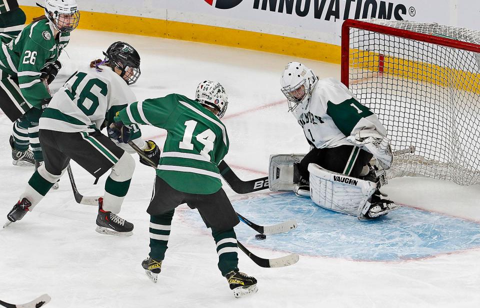 Dragon #16 Lily McGoldrick works to clear the puck under pressure from Bulldog Ellie Bohane in front of goalie Anna McGinty.The Duxbury High girls hockey team won the Division 2 state championship at TD Garden after defeating Canton on Sunday March 19, 2023 