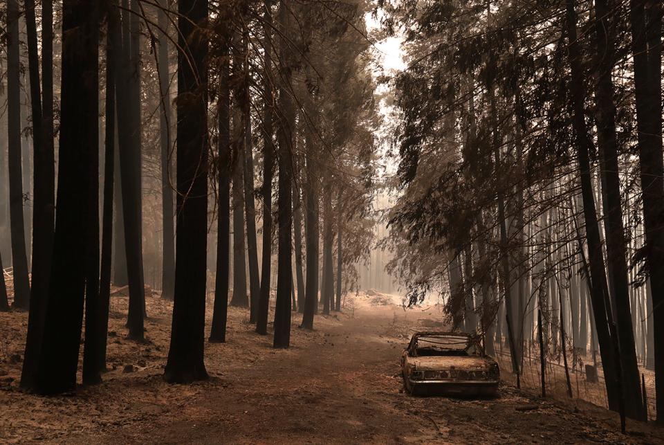 A burned out vintage Ford Mustang in the Pineridge neighborhood of the Santa Cruz Mountains community of Bonny Doon near Santa Cruz, Calif., is seen, Thursday, Aug. 20, 2020, where the CZU August Lightning Complex fire has grown.