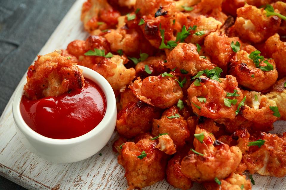 Eine vegane Alternative zu Chicken-Wings sind Cauliflower Wings - und zudem sehr gesund. Für dieses Finger-Food teilt man den Blumenkohl in kleine Stücke, paniert diese in einem Teig aus Kichererbsenmehl, Pflanzenmilch, Knoblauch, Paprika, Salz und Pfeffer. Nach 20 Minuten im Ofen mit Barbecue-Sauce bepinseln und für weitere 15 Minuten knusprig backen. (Bild: iStock/DronG)