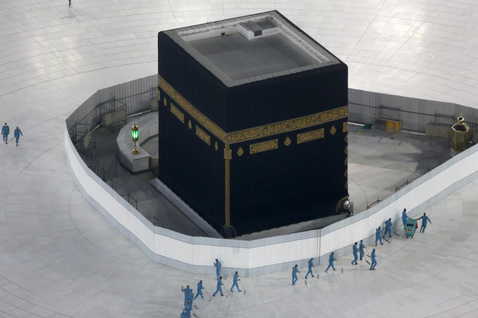 FILE - In this March 7, 2020 file photo, workers disinfect the ground around the Kaaba, the cubic building at the Grand Mosque, in the Muslim holy city of Mecca, Saudi Arabia after authorities emptied Islam's holiest site for sterilization over fears of the new coronavirus. Saudi Arabia said Tuesday, June 22, 2020 this year’s hajj will not be canceled, but that due to the coronavirus only “very limited numbers” of people will be allowed to perform the pilgrimage that traditionally draws around 2 million people from around the world to Mecca once a year. (AP Photo/Amr Nabil, File)