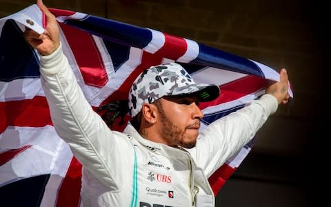Mercedes AMG Petronas Motorsport driver Lewis Hamilton (44) of Great Britain holds up the Union Jack as he celebrates winning his sixth world championship after he finishes in second place in the United States Grand Prix at Circuit of the Americas. - Credit: USA TODAY Sports