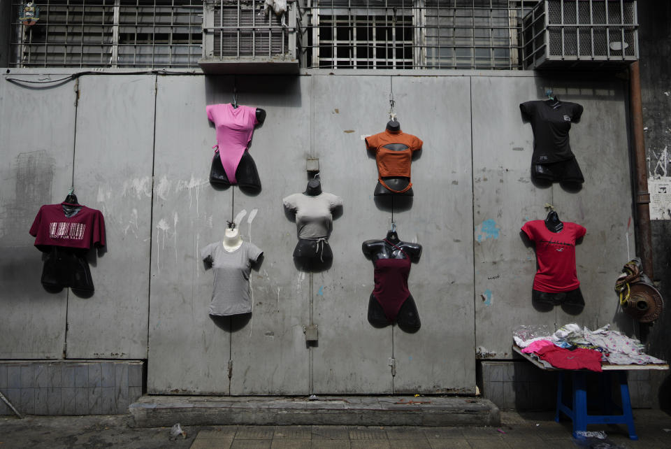 Mannequins displaying women's clothing for sale hang from a gate, in Caracas, Venezuela, Friday, Oct 1, 2021. A new currency with six fewer zeros debuts today in Venezuela, whose currency has been made nearly worthless by years of the world's worst inflation. The new currency tops out at 100 bolivars, a little less than $25 until inflation starts to eat away at that as well. (AP Photo/Ariana Cubillos)