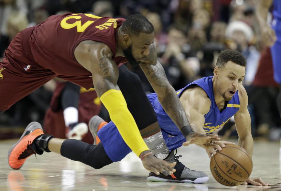 Cleveland Cavaliers' LeBron James, left, and Golden State Warriors' Stephen Curry battle for a loose ball in the second half of an NBA basketball game, Sunday, Dec. 25, 2016, in Cleveland. The Cavaliers won 109-108. (AP Photo/Tony Dejak)