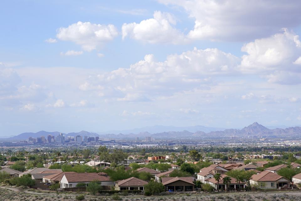 FILE - With the downtown skyline in the background, expansive urban sprawl continues to grow, Aug. 12, 2021, in Phoenix. According to population estimates released Thursday, March 30, 2023, by the U.S. Census Bureau, Maricopa County, Ariz., home to Phoenix, had the biggest gain of any U.S. county, with almost 57,000 new residents in 2022. (AP Photo/Ross D. Franklin, File)