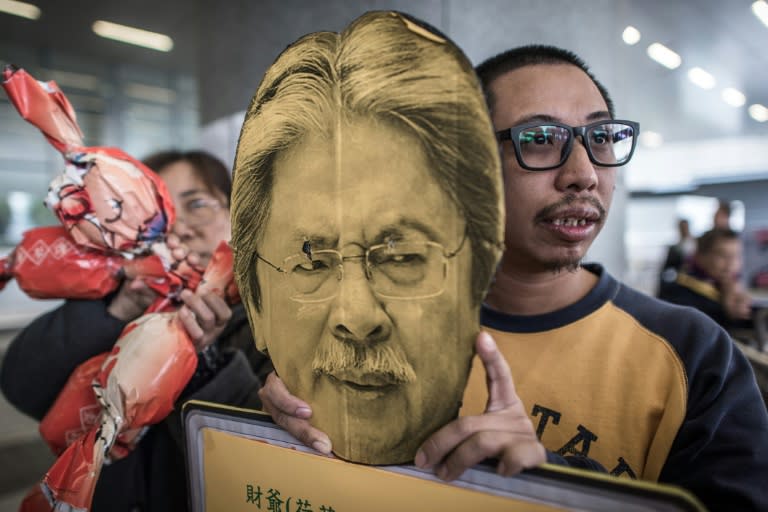 A demonstrator holds a placard depicting Hong Kong's Financial Secretary John Tsang Chun-wah, as people protest against the new budget, outside the government buildings, on February 24, 2016