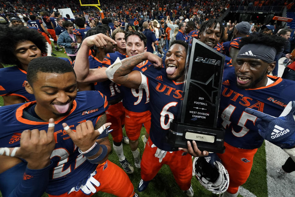 UTSA players celebrate with their conference trophy after their win over UAB in an NCAA college football game, Saturday, Nov. 20, 2021, in San Antonio. The win (AP Photo/Eric Gay)