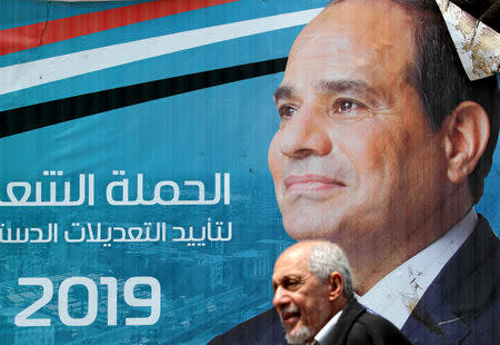 FILE PHOTO: A man walks in front of a banner depicting Egyptian President Abdel Fattah al-Sisi before the upcoming referendum on constitutional amendments in Cairo, Egypt April 16, 2019. REUTERS/Mohamed Abd El Ghany