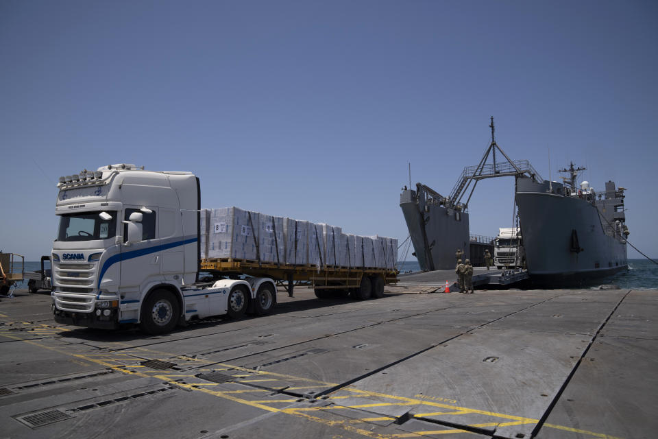 U.S. Army soldiers stand next to trucks arriving loaded with humanitarian aid at the U.S.-built floating pier Trident before reaching the beach on the coast of the Gaza Strip, Tuesday, June 25, 2024. (AP Photo/Leo Correa)