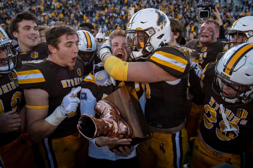 Wyoming football players celebrate their 31-17 victory over Colorado State in a 2021 game at War Memorial Stadium in Laramie, Wyoming. Texas Tech and Wyoming play a season opener Saturday at the same stadium, which sits at the highest-elevation of any in major-college football.