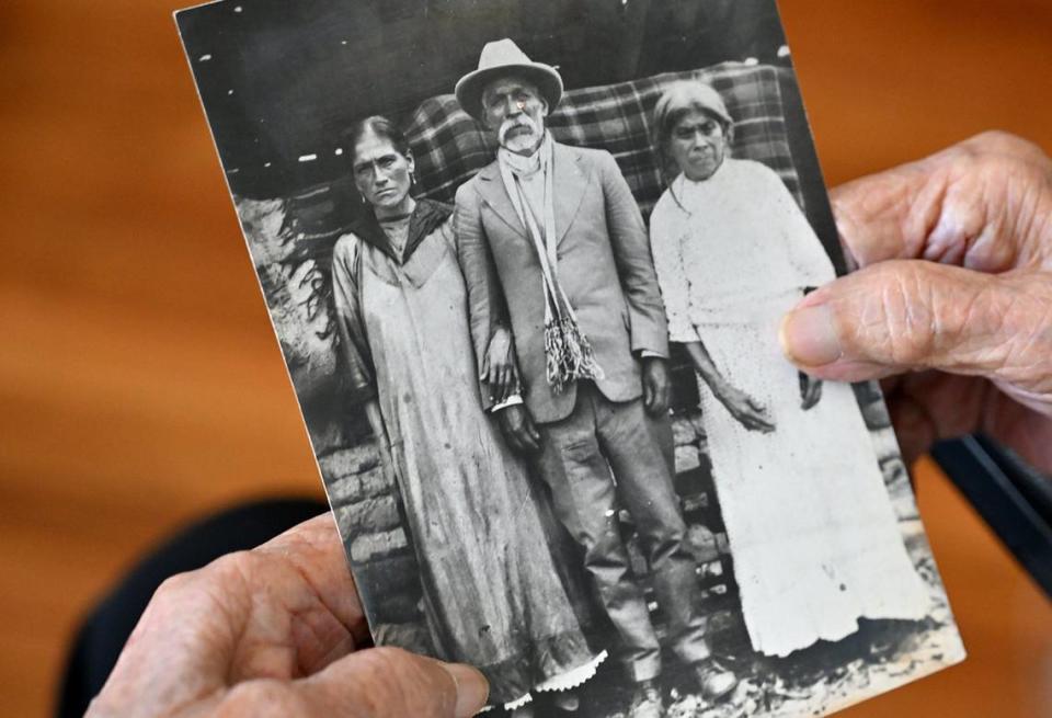 Elvira Madrigal, quien acaba de cumplir 107 años, sostiene una vieja fotografía de sus padres Matilde y José, a la izquierda y en el centro, y de su abuela Luz, a la derecha. Fue fotografiada el martes 7 de mayo de 2024 en su casa de Fresno.