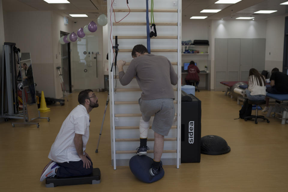 A physiotherapist assists Israeli soldier, Raphael, 21, during his treatment session at the new Gandel Rehabilitation Center of the Hadassah hospital, in Jerusalem, Israel, Wednesday, Feb. 21, 2024. Raphael was injured on the leg by shrapnel during the battles against Hamas in Khan Younis, Gaza Strip, last December. (AP Photo/Leo Correa)