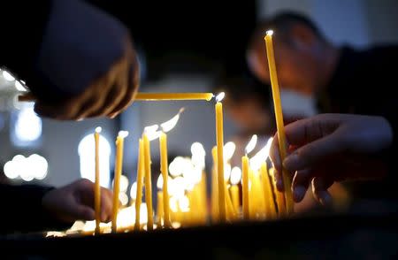 People light candles in memory of the victims of mass killings of Armenians by Ottoman Turks at the main cathedral in Echmiadzin, April 23, 2015. REUTERS/David Mdzinarishvili