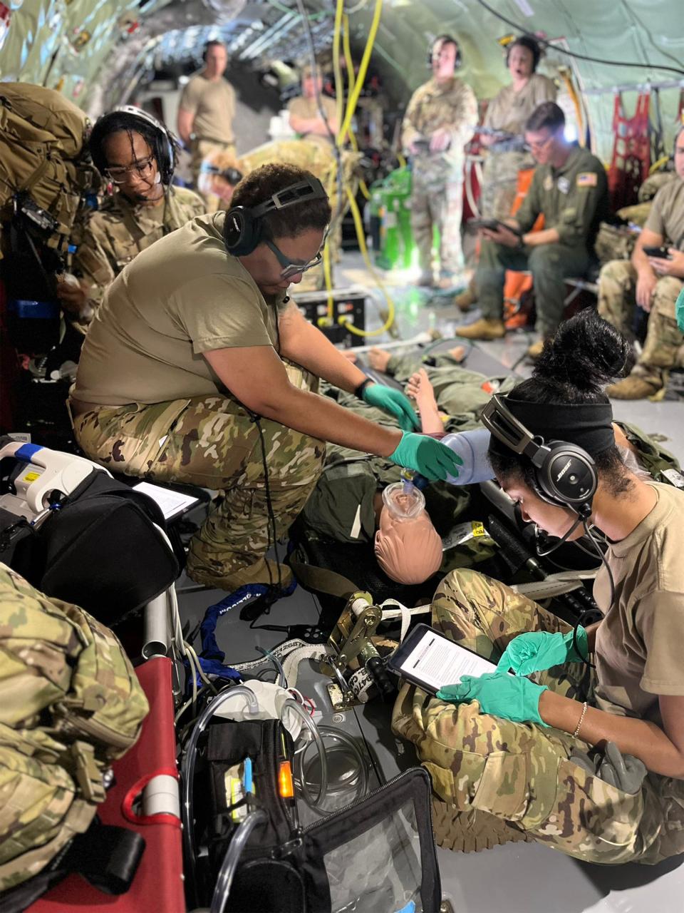 Capt. Amber McKenzie, left, a flight nurse with the 908th Aeromedical Evacuation Squadron, supervises Tech. Sgt. Brittany Storey, center, and Staff. Sgt. Jakiya Randall, 908th AES aeromedical technicians, providing emergency medical care on a simulated patient Nov. 7, 2023, during a training flight from Maxwell Air Force Base, Alabama, to Key West, Florida.