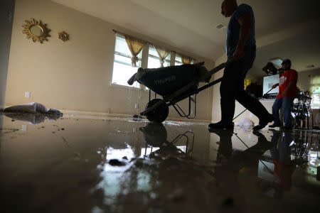 Daniel Vasquez removes a damaged carpet after Tropical Storm Harvey flooded his home in east Houston, Texas, U.S. September 3, 2017. Vasquez and his family, originally from El Salvador, spent six days at the shelter after being airlifted by rescue helicopter. Vasquez, a truck driver who supports a family of five, did not hold flood insurance. REUTERS/Carlos Barria