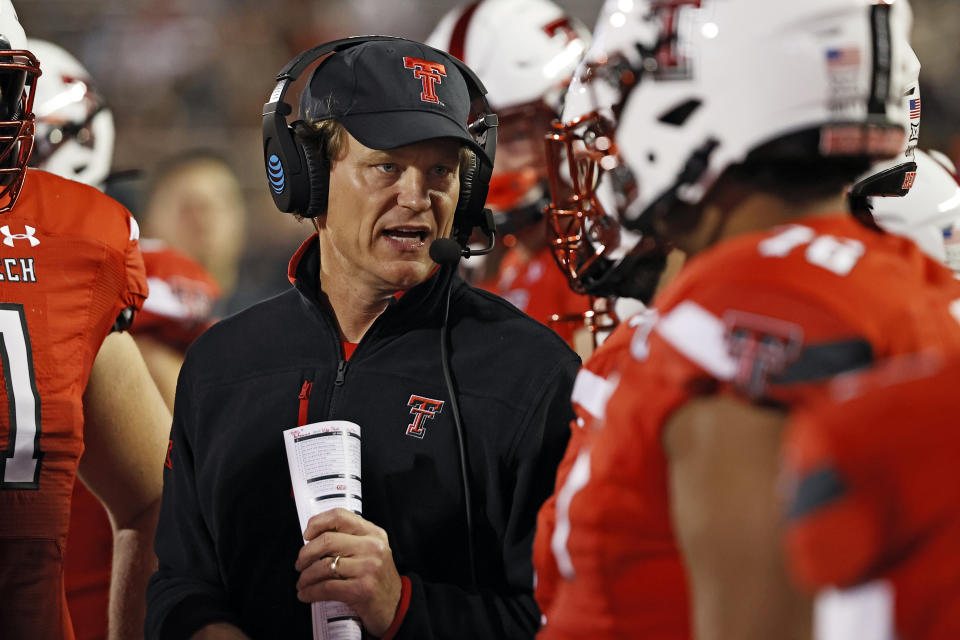 Texas Tech interim coach Sonny Cumbie talks to his players on the sideline during the first half of an NCAA college football game against Oklahoma State, Saturday, Nov. 20, 2021, in Lubbock, Texas. (AP Photo/Brad Tollefson)