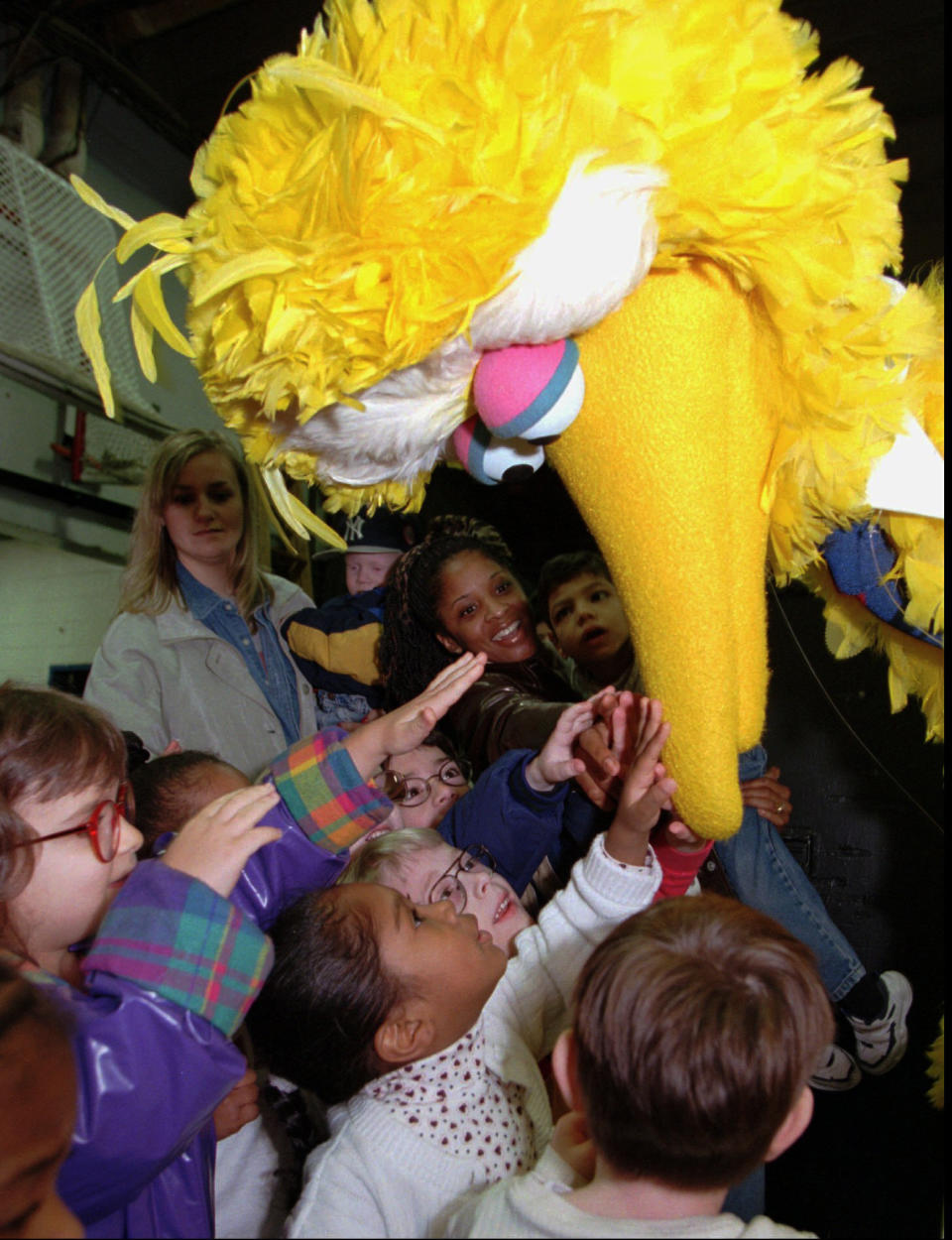 FILE - In this March 20, 1998, file photo, students from the Overbrook School for the Blind reach up and touch the beak of Sesame Street's Big Bird character before his performance in Philadelphia. Officials with SeaWorld Entertainment and Sesame Workshop announced Monday, Oct. 21, 2019, that they are opening the country’s second Sesame Place park in San Diego in 2021. The first Sesame Place opened almost 40 years ago outside Philadelphia. (AP Photo/Chris Gardner, File)