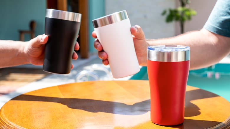 People holding insulated tumblers