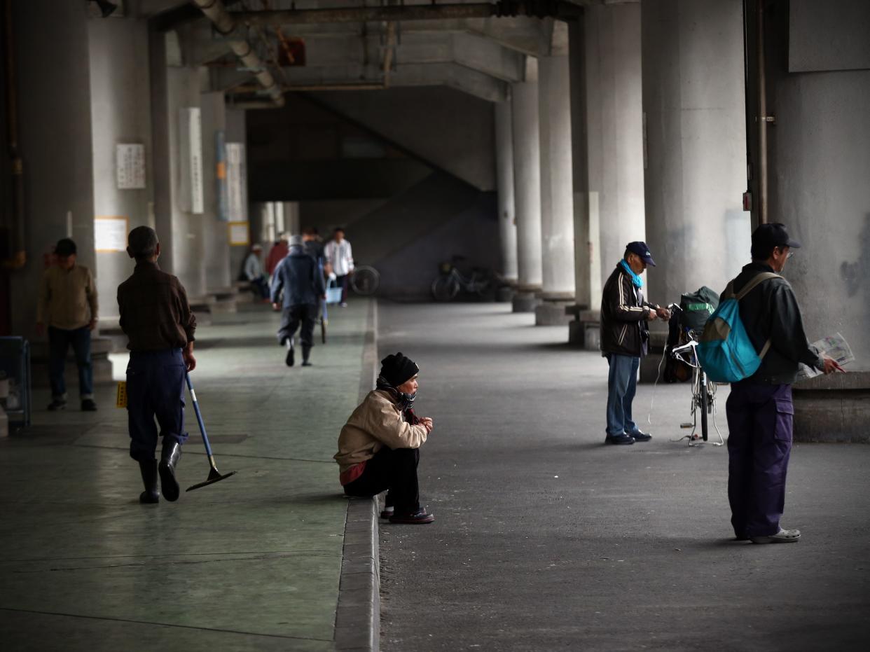 Homeless men wait around for the offer of work in the slum area of Kamagasaki on April 23, 2016 in Osaka, Japan.