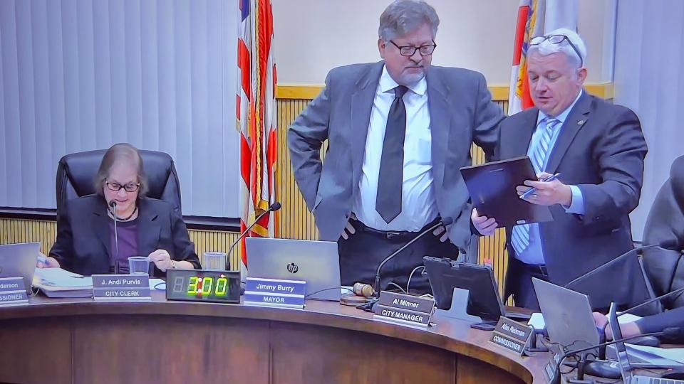 Leesburg City Manager Al Minner presents Mayor Jimmy Burry with a recognition plaque at the city commission's Jan. 8 meeting.