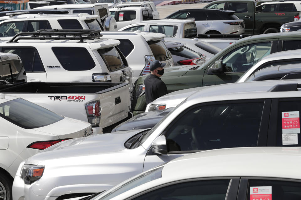 An official with Homeland Security Investigations walks among vehicles worth an estimated $3.2 million, at Port Everglades after they were seized by Homeland Security Investigations, Wednesday, July 8, 2020, in Fort Lauderdale, Fla. The vehicles were to be smuggled to Venezuela in violation of U.S. export laws and sanctions against the socialist Venezuelan government. (AP Photo/Lynne Sladky)