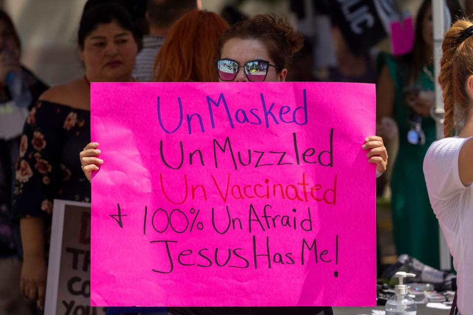 A woman holds a sign proclaiming her belief that she doesn't need to be vaccinated or wear a mask because Jesus will protect her from coronavirus, as anti-vaccination protesters pray and rally near City Hall after the Los Angeles City Council voted earlier this week to create an ordinance requiring proof of vaccination to enter many indoor public spaces, in Los Angeles, August 14, 2021. (Photo by DAVID MCNEW / AFP) (Photo by DAVID MCNEW/AFP via Getty Images)