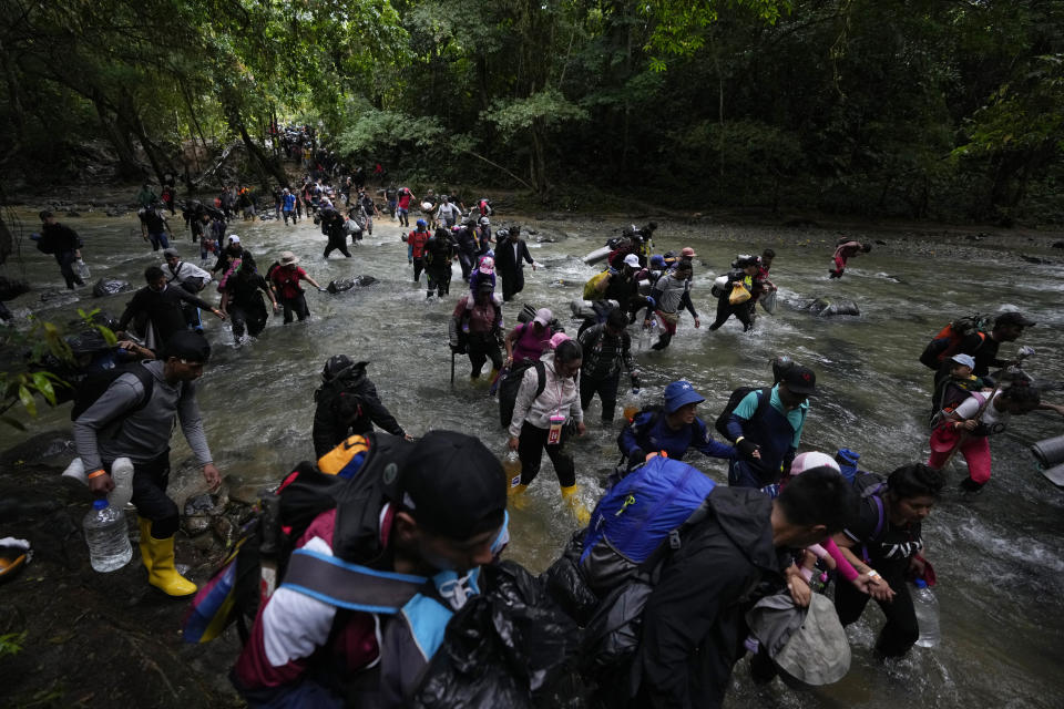 FILE - Migrants, mostly Venezuelans, cross a river during their journey through the Darien Gap from Colombia into Panama, hoping to reach the U.S., Oct. 15, 2022. (AP Photo/Fernando Vergara, File)