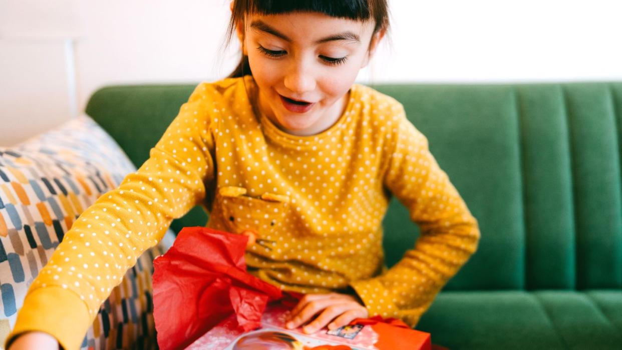 7 year old girl opening up gift