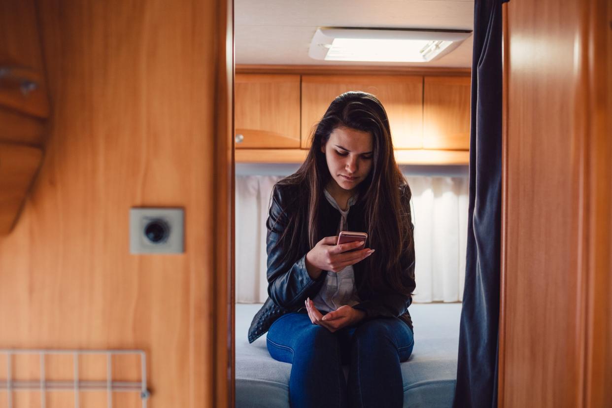 Girl in campervan using smartphone