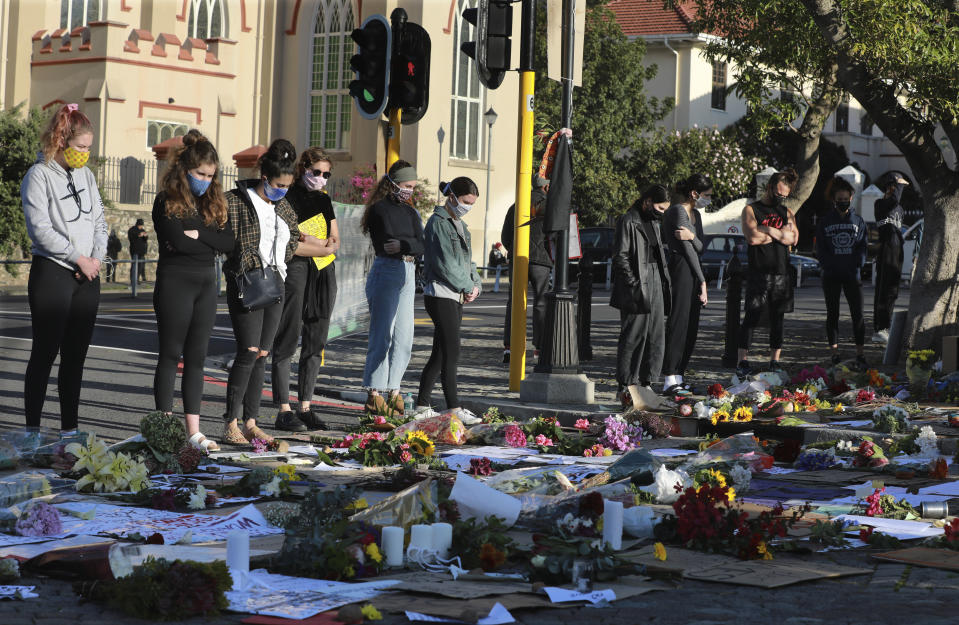 FILE - In this Wednesday June 3, 2020 file photo demonstrators look at flowers as they attend a protest outside parliament in Cape Town, South Africa, over the death of George Floyd, a black man who died after being restrained by Minneapolis police officers on May 25. (AP Photo/Nardus Engelbrecht, File)