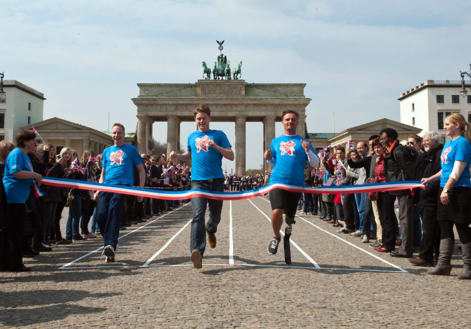 German Paralympic competitor Heinrich Popow, right, participates a 100 meter race at Berlin's landmark Brandenburg Gate, Wednesday, April 18, 2012. The race was organized by the British embassy in Berlin 100 days ahead of the London 2012 Olympics, in which athletes and employees of the embassy participated. (AP Photo/dapd, Paul Zinken)