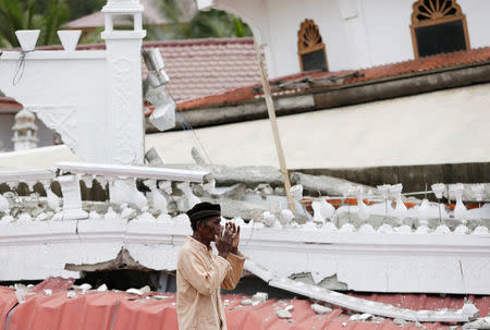 A Muslim man attends Friday prayers at Jami Quba mosque which collapsed during this week's earthquake in Pidie Jaya, Aceh province, Indonesia December 9, 2016. REUTERS/Darren Whiteside