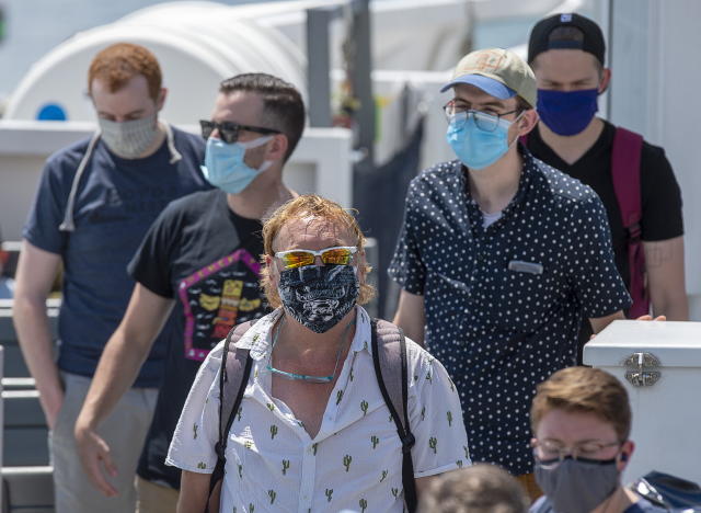 Passengers wear face masks on a Halifax Transit ferry as it arrives in Dartmouth, N.S. on Friday, July 24, 2020, the first day they have been mandatory on public transit. Masks will become mandatory in most indoor public places in Nova Scotia on Friday and the province's health minister says it will be up to the public to carry out its responsibility to wear them. THE CANADIAN PRESS/Andrew Vaughan