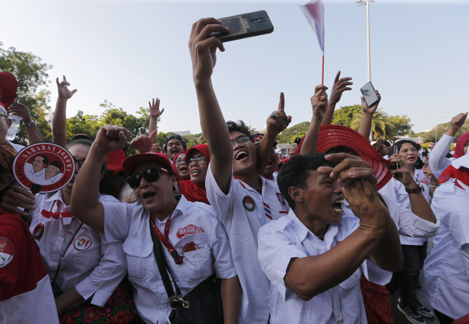 Supporters of Indonesian President Joko Widodo holds a large national Red-White flag during rally to celebrate his inauguration for his second term in Jakarta, Indonesia, Sunday, Oct. 20, 2019. Indonesian President Joko Widodo, who rose from poverty and pledged to champion democracy, fight entrenched corruption and modernise the world's most populous Muslim-majority nation, was sworn in Sunday for his second and final five-year term with a pledge to take bolder actions. (AP Photo/Tatan Syuflana)