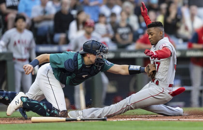 El catcher de los Marineros de Seattle Cal Raleigh elimina a Magneuris Sierra, de los Angelinos de Los Ángeles, en el plato en el segundo inning del juego de la MLB que enfrentó a ambos equipos, el 5 de agosto de 2022, en Seattle. (AP Foto/Stephen Brashear)