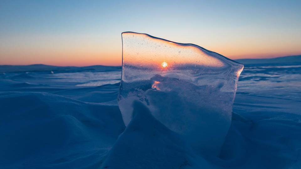 Beautiful sunrise sky over frozen water Lake Baikal Siberia