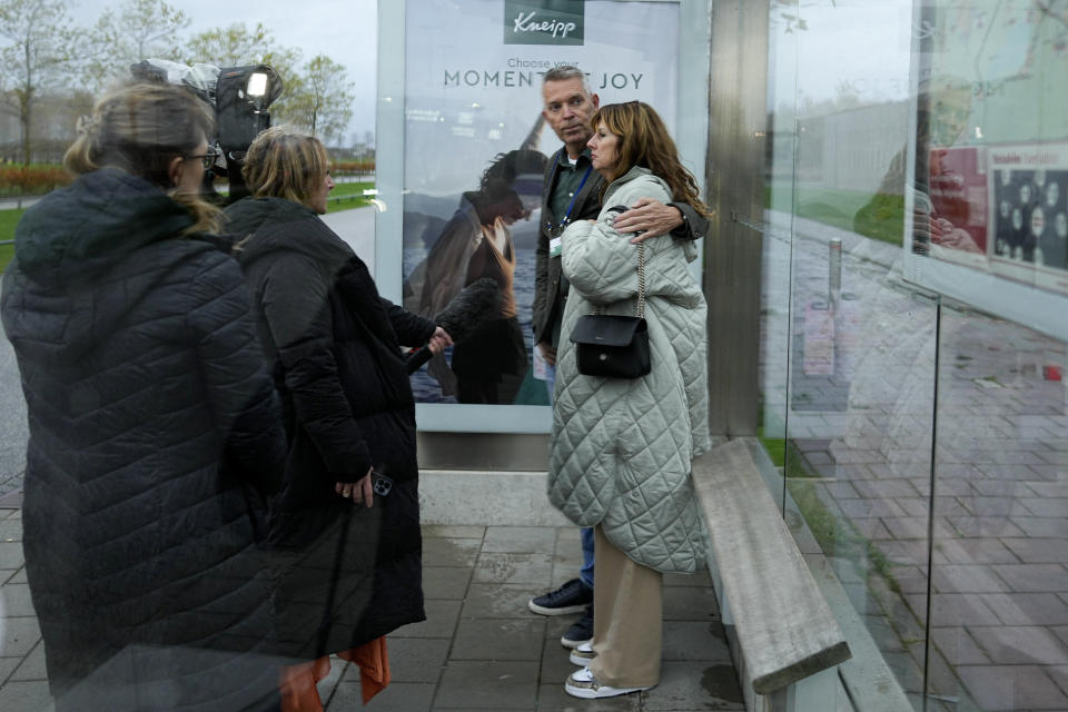 People who lost relatives in the downing of MH17, hug at a bus stop after the court's verdict at Schiphol airport, near Amsterdam, Netherlands, Thursday, Nov. 17, 2022. A Dutch court has convicted two Russians and a Ukrainian of the murders of 298 people who died in the 2014 downing of Malaysia Airlines flight MH17 over Ukraine. One Russian was acquitted for lack of evidence. (AP Photo/Phil Nijhuis)