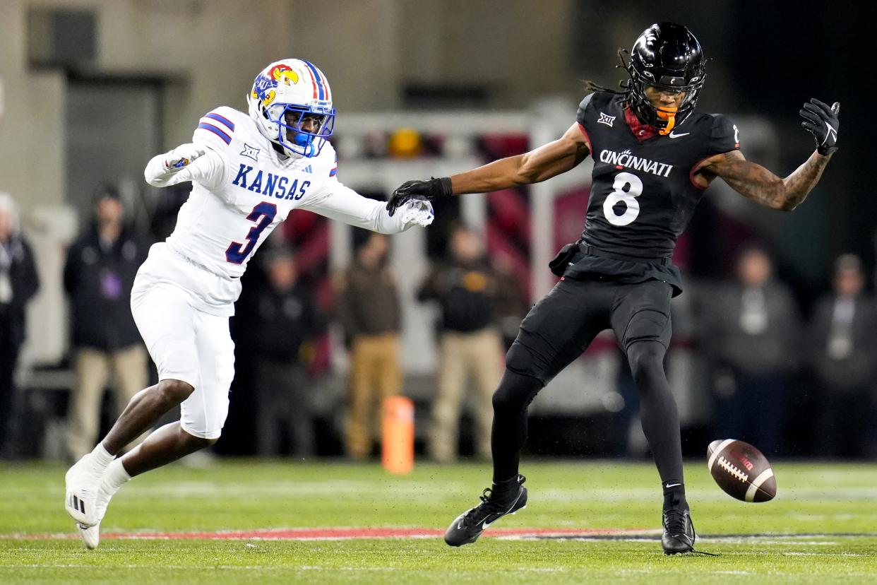 Cincinnati Bearcats wide receiver Xzavier Henderson (8) attempts to catch an incomplete pass with Kansas Jayhawks cornerback Mello Dotson (3) on his trail during the NCAA college football game between the Cincinnati Bearcats and Kansas Jayhawks on Saturday, Nov. 25, 2023, at Nippert Stadium in Cincinnati. This is the Bearcats’ last game of the season, as well as their Senior Night Saturday.