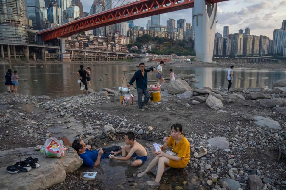 People sit in a shallow pool of water in the riverbed of the Jialing River, a tributary of the Yangtze, in southwestern China's Chongqing Municipality (AP)