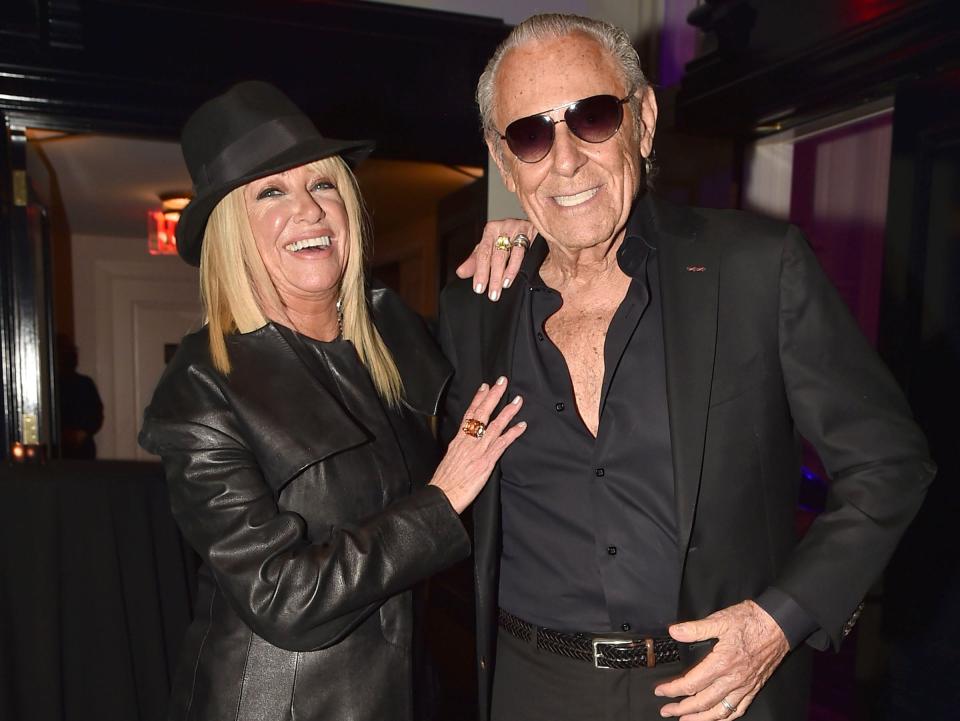 Suzanne Somers and Alan Hamel pose together in black outfits at a formal event.