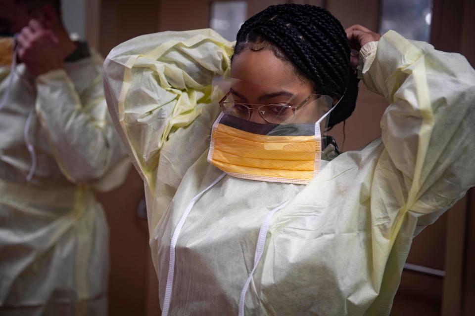 Kaylah Jenkins dons personal protective equipment during infection control training aboard the USNS Comfort as the ship transits the Atlantic Ocean on its way to New York City on March 29, 2020.