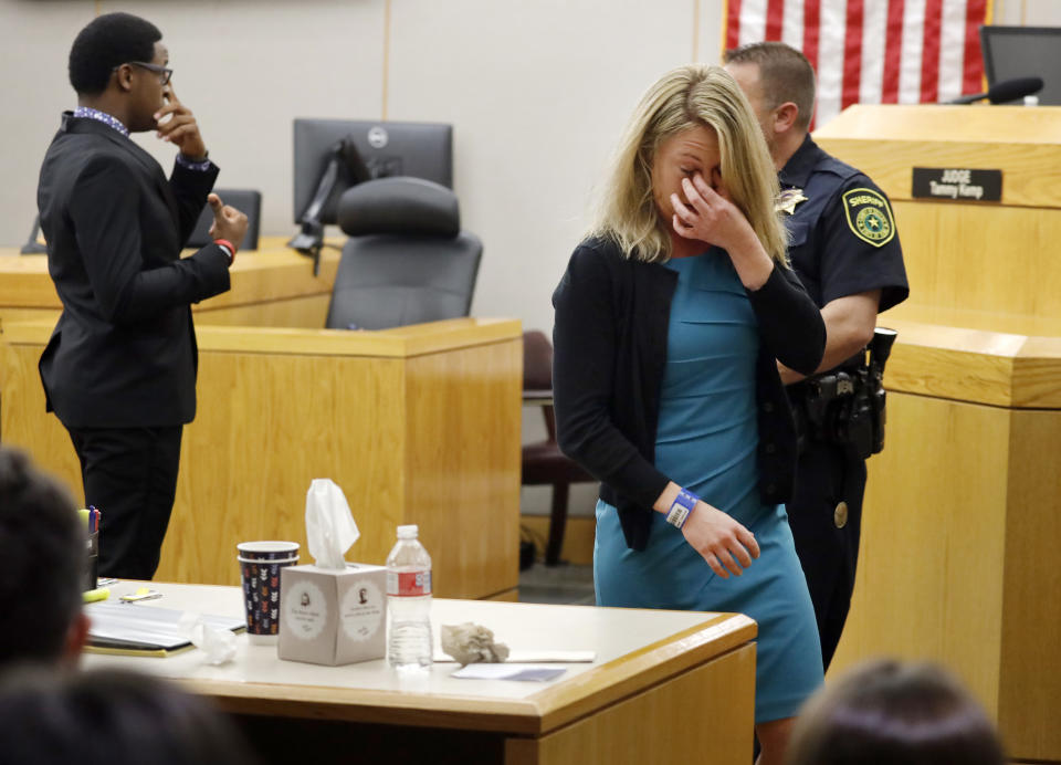 Former Dallas Police Officer Amber Guyger walks back to her desk after hugging victim Botham Jean's younger brother Brandt Jean after he delivered his impact statement to her following Guyger's sentencing, Wednesday, Oct. 2, 2019, in Dallas. Guyger, who said she mistook neighbor Botham Jean's apartment for her own and fatally shot him in his living room, was sentenced to a decade in prison. (Tom Fox/The Dallas Morning News via AP, Pool)