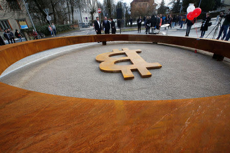 People attend the opening ceremony of world's first public Bitcoin monument, placed at a roundabout connecting two roads at the city centre in Kranj, Slovenia, March 13, 2018. REUTERS/Borut Zivulovic