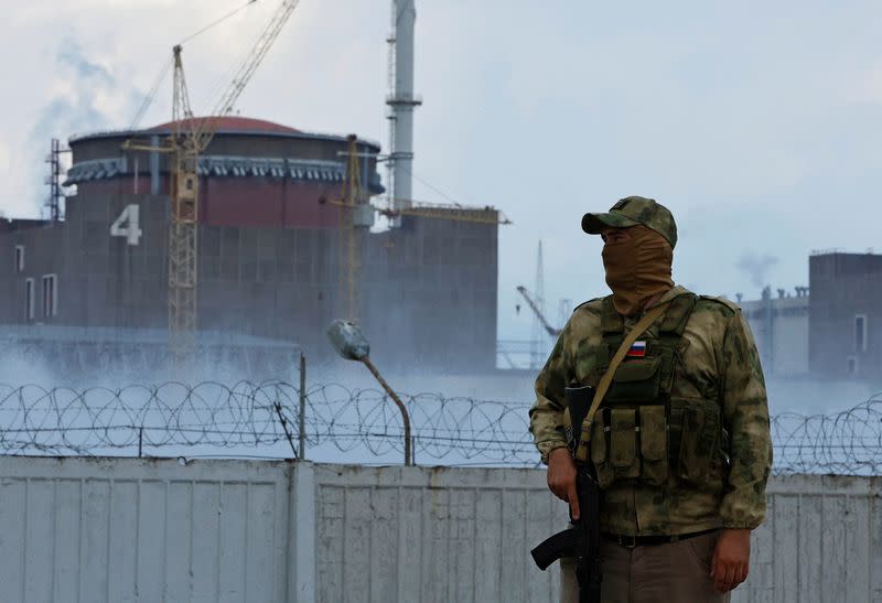 Un militar con una bandera rusa en su uniforme hace guardia cerca de la planta de energía nuclear de Zaporiyia, en medio del conflicto entre Ucrania y Rusia en las afueras de la ciudad de Enerhodar, controlada por Rusia, en la región de Zaporiyia , Ucrania