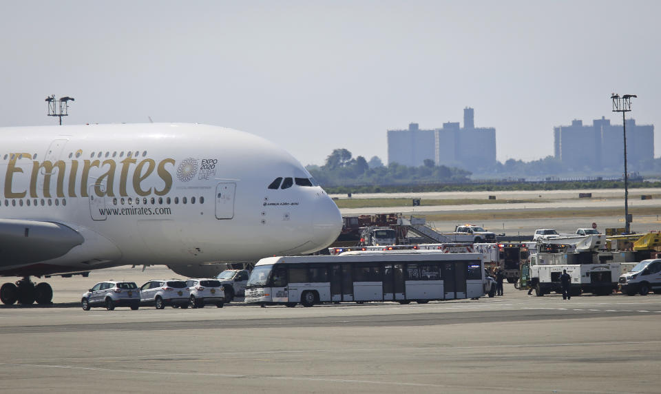 Emergency response crews gather outside a plane at New York's Kennedy Airport amid reports of ill passengers aboard a flight from Dubai, Wednesday, Sept. 5, 2018. (AP Photo/Bebeto Matthews)