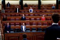 Spanish PM Sanchez and deputies stand up during a minute of silence at the start of a session on coronavirus disease (COVID-19) at Parliament in Madrid